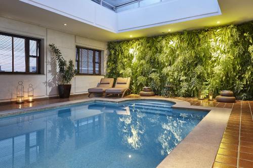 圣保罗圣保罗波尔图湾酒店的一座带绿色墙壁的别墅内的游泳池