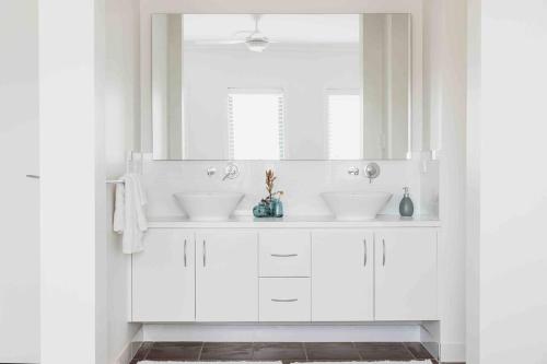 CanowindraThe Oaks Country Getaway的白色的浴室设有两个盥洗盆和镜子