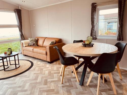 WesterlandChalet direct aan Waddenzee的客厅配有桌子和沙发