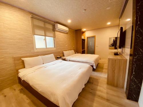 礁溪山水妍旅店-礁溪的酒店客房设有两张床和窗户。