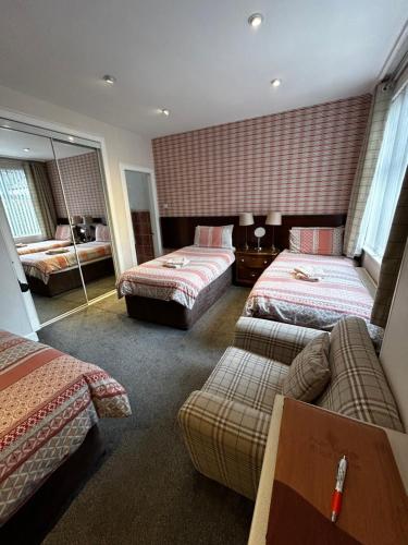 爱丁堡阿陈瑞轩宾馆的酒店客房,设有两张床和一张沙发