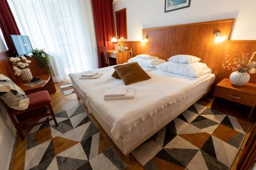 布达佩斯HELIOS Hotel Apartments的一间卧室配有一张大床和木制床头板