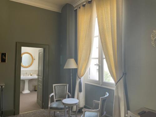 阿让加克兵城堡酒店的客房设有窗户和桌椅。