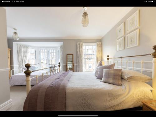 克罗默Albury House的一间卧室设有一张床和两个窗户。