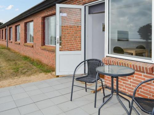 孔斯马克Apartment Baltser - 5km from the sea in Western Jutland by Interhome的天井配有两把椅子和一张桌子,门