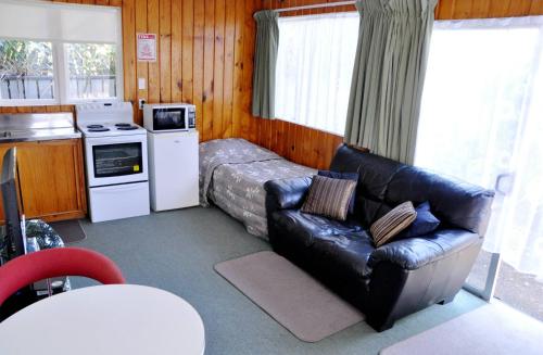 新普利茅斯宝莱默酒店的带沙发和床的客厅以及厨房。