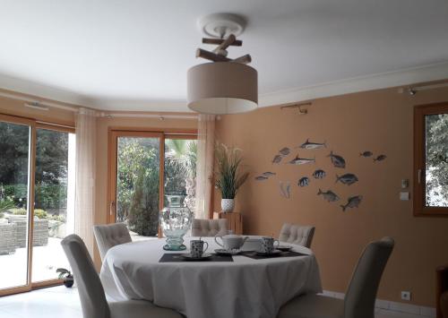 拉波勒Belle de Dune的用餐室配有一张桌子,墙上挂着鱼