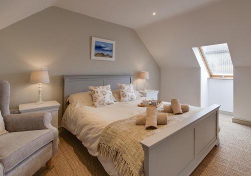 AttlebridgeLittle Owl Loft的卧室配有床、椅子和窗户。