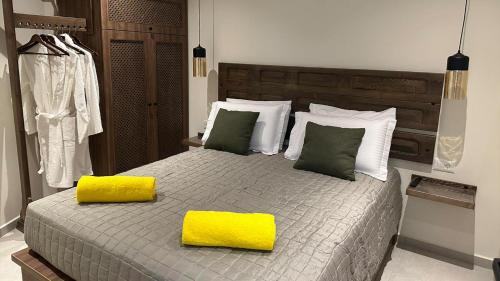 锡米Amalthea Luxury Suites的一间卧室配有一张大床和两张黄色枕头