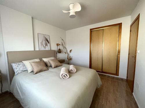 托雷维耶哈Salty Apartment Torrevieja的卧室配有带毛巾的大型白色床