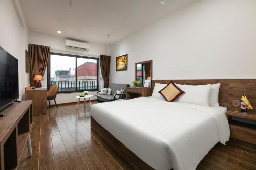 河内Hanoi Saga Hotel的卧室配有一张白色大床和电视。