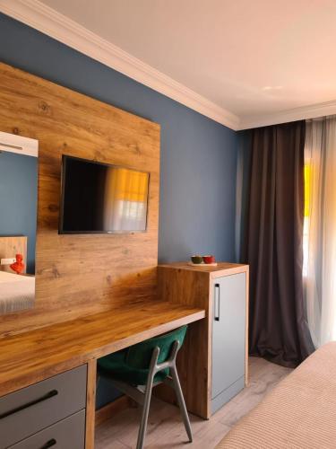 戈西克Ekin Otel Göcek的卧室配有一张桌子,墙上配有电视