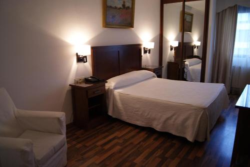 瓜迪克斯穆拉森酒店的配有一张床和一把椅子的酒店客房