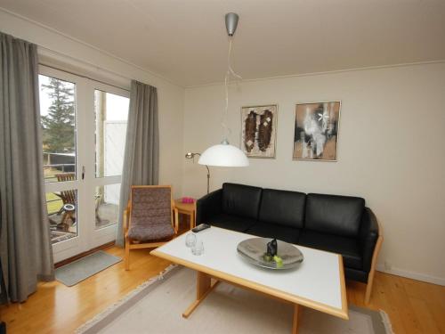海尔斯Apartment Runhild - 100m from the sea in NE Jutland by Interhome的客厅配有黑色沙发和桌子