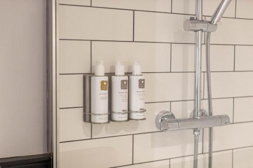 卡特梅尔Royal Oak的浴室墙上有3瓶洗发水