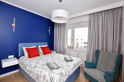 托伦Apartament Nr 50, 2 sypialnie, wygodny parking podziemny的蓝色卧室,配有床和椅子