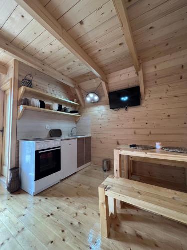 新瓦罗什Brvnare Puljci的大型厨房设有木墙和木地板