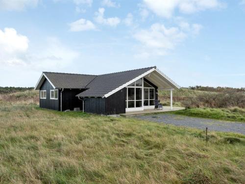 希茨海尔斯Holiday Home Frejdis - 1-1km from the sea in NW Jutland by Interhome的田野中的黑白房子