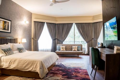 伊斯兰堡Hillside Residence E-7 by Paramount Hospitality的一间卧室配有一张床、一张桌子和一张沙发