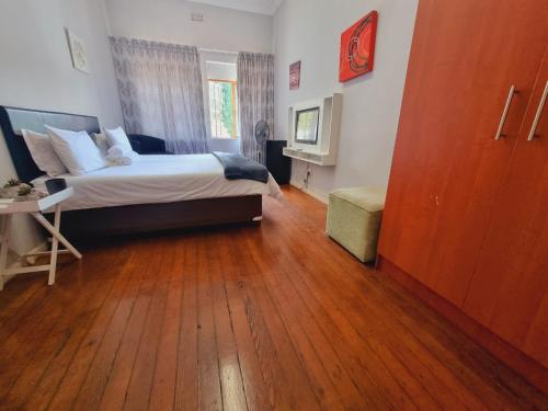 约翰内斯堡Houghton Skye的一间卧室配有一张床,铺有木地板