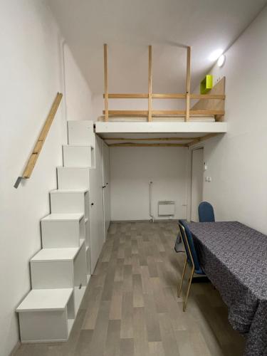 卢布尔雅那ICE APARTMENT的客房设有楼梯、床和桌子。
