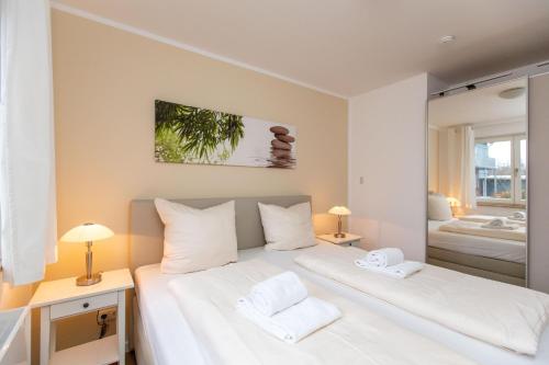 普劳西Hafendorf Haus 7_ Apartment 4的卧室配有一张白色大床和2条白色毛巾