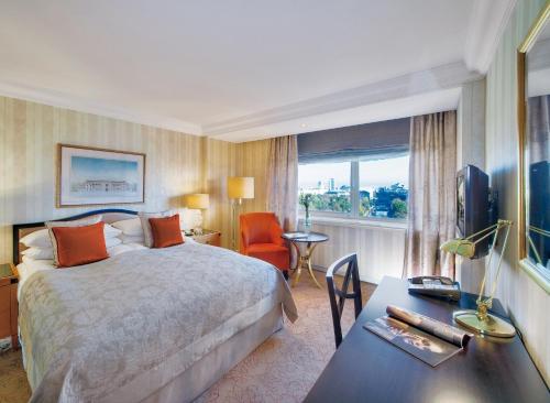 维也纳维也纳洲际酒店的配有一张床、一张书桌和一扇窗户的酒店客房