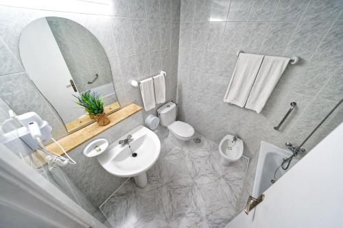 波多黎各里约皮埃德拉斯公寓酒店的一间带水槽、卫生间和镜子的浴室