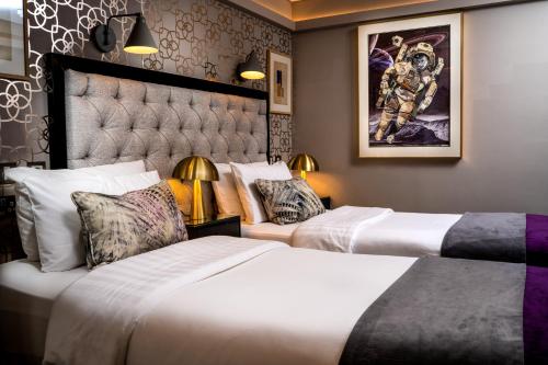 都柏林罗科斯福德酒店的酒店客房设有两张床,墙上挂有绘画作品