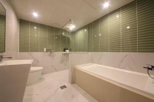 釜山Hotel Prima Busan的带浴缸、卫生间和盥洗盆的浴室