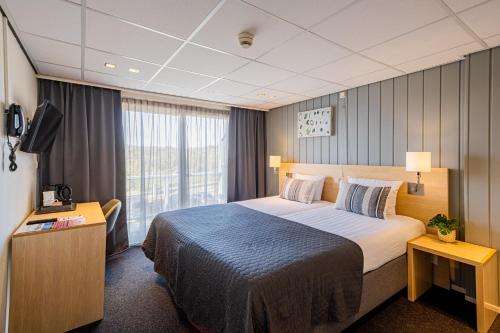 海边的艾格蒙特德布依酒店的酒店客房设有一张大床和一台电视。