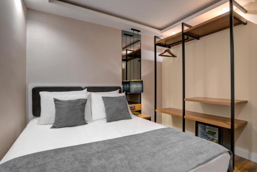 伊斯坦布尔Depiero Hotel Karaköy的卧室配有带灰色和白色枕头的床