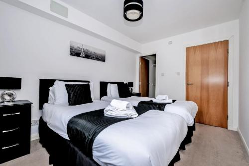 阿伯丁Orange Apartments - Kepplestone的白色和黑色客房的两张床