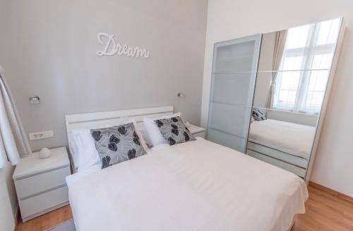 萨格勒布Main Square Dream Apartment的卧室配有白色的床和镜子