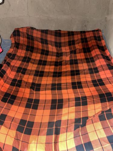 姆托瓦姆布DUPOTO HOMESTAY VILLAGE - MASAI VILLAGE (BOMA)的床上的毯子被贴近
