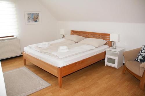沃尔特湖畔韦尔登Haus Sonnental Velden am Wörthersee的一间卧室配有一张床、一张沙发和一把椅子