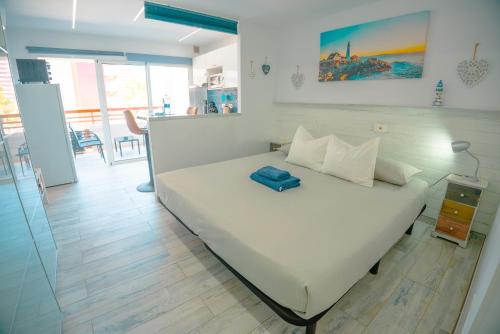 马斯帕洛马斯Piso Paraíso vicino al mare的卧室配有白色的床和蓝色枕头