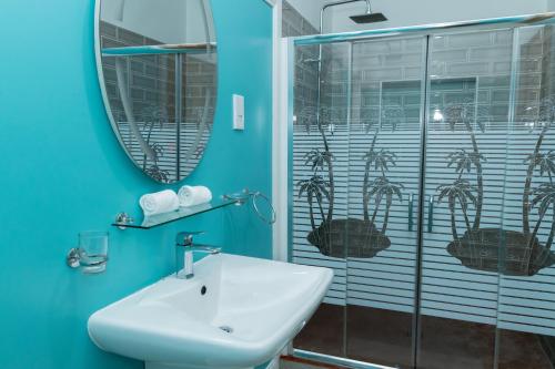 安塞罗亚莱kannel Apartments的蓝色的浴室设有水槽和镜子