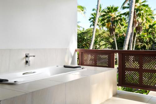丹娜努斐济丹娜拉岛威斯汀spa度假酒店的一间带水槽的浴室和一个种植了棕榈树的阳台
