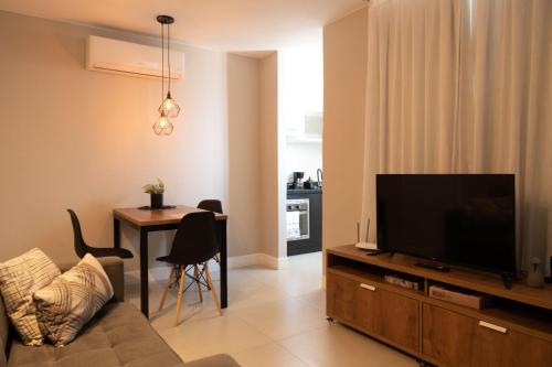 里约热内卢Art Inn Porto的客厅配有平面电视和桌子。