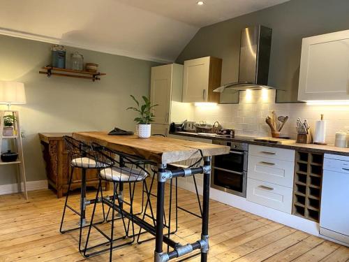 阿利士Charming, rustic & well equipped garden cottage的厨房配有桌子和一些凳子