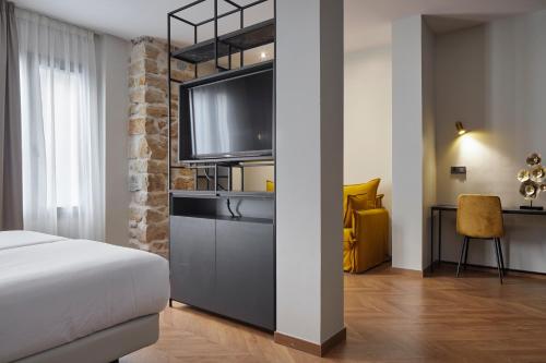 圣塞瓦斯蒂安HOTEL ARRIZUL CATEDRAL的一间卧室配有一张床和一台平面电视