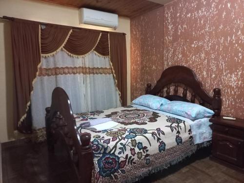 伊瓜苏港Salto dos hermanas的一间卧室配有一张带鲜花毯子的床和窗户。