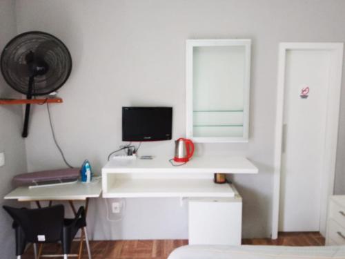 布卢梅瑙Espaço aconchegante Blumenau的一间设有白色书桌的房间,里面配有一台电脑