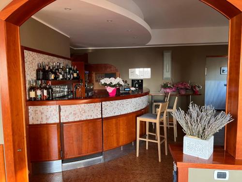 弗拉穆拉Hotel Meri 1956 Locanda e Cucina的一间酒吧,位于带柜台和椅子的房间内