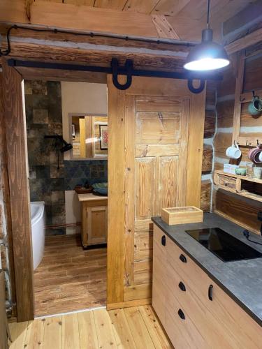 ZatwarnicaChyża Hapełe的铺有木地板,设有木墙厨房。