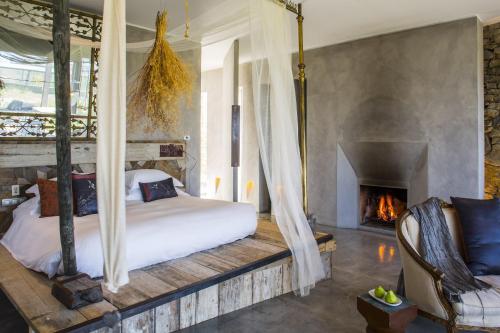 圣克鲁斯Areias do Seixo Hotel的一间卧室配有一张床和一个壁炉