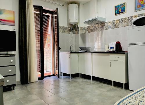 埃希哈LA CASA MIRADOR DE ÉCIJA的一间厨房,配有白色的橱柜和大窗户