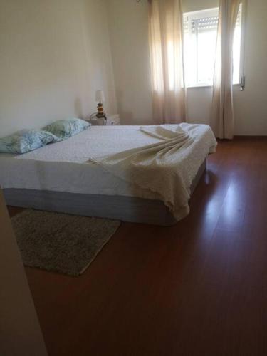 埃斯托伊Maravilhoso apartamento T2 Estoi的一间卧室设有一张床和一个窗口