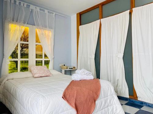 莫拉塔利亚Casa Levante - Casa Rural Los Cuatro Vientos的卧室配有白色的床和窗户。